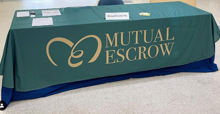 Table throw with Mutual Escrow logo.