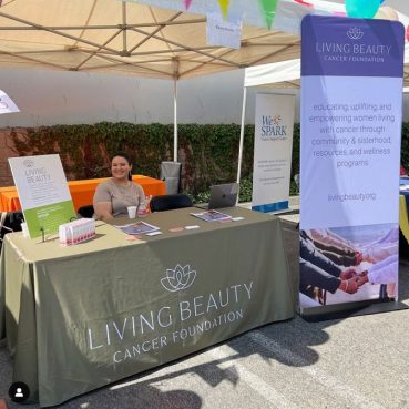 Table throw and banner stand with Living Beauty logo on it.